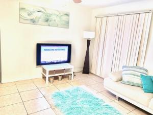 sala de estar con TV y sofá en FLiXBEDS - Airport Hostel Book Now! Under New Management, en Fort Lauderdale