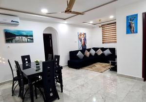 a living room with a black couch and a table at Douglas Luxury Apartments At Douglas Court, Adenta, Accra in Accra