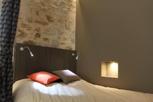uma cama com dois travesseiros em um quarto em Une Pause a Signes em Signes