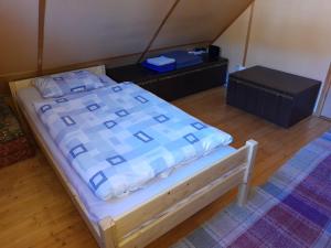 a bed with a blue and white comforter in a room at U včelárov in Mýto pod Ďumbierom