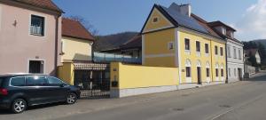 un pequeño coche aparcado frente a un edificio amarillo en Stift Göttweigblick en Furth