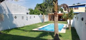 a palm tree and a swimming pool in a yard at Casa piscina Atlantida in Atlántida