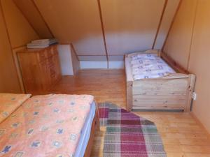 a room with two beds and a wooden floor at U včelárov in Mýto pod Ďumbierom