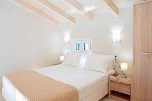 1 dormitorio con cama blanca y techo de madera en Anthemis Luxury Villas, en Ligia