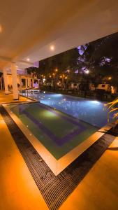 a swimming pool at night with a large tv above it at Tamarind Moon in Dickwella