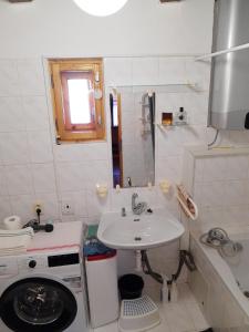 a small bathroom with a sink and a washing machine at U včelárov in Mýto pod Ďumbierom