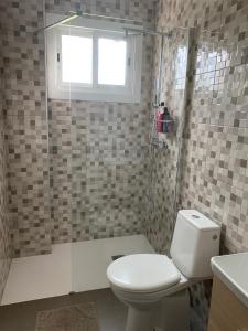 een badkamer met een toilet en een douche met een raam bij Apartamento El Nogal 1 in Tui