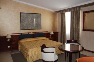 a hotel room with a bed and a table at Aretusa Palace Hotel in Syracuse