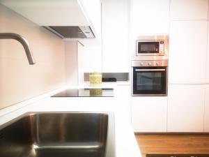 a kitchen with a sink and a microwave at EL DESCANSO DE CARBAYEDO in Avilés +17 photos