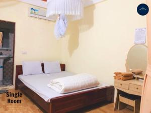 a small bedroom with a bed and a mirror at Ba Be Lake View Homestay in An Ma