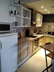 a kitchen with white cabinets and a white refrigerator at Chez Do.. in Beinheim