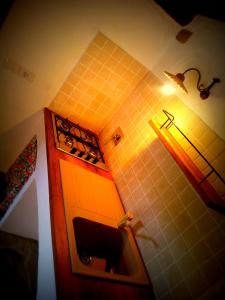 uma cozinha com uma parede de azulejos amarelos com uma luz em Navilla em Torresina