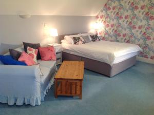 a hotel room with two beds and a couch at Dragonfly Cottage, Rattlesden in Rattlesden