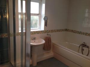 uma casa de banho com uma banheira e um lavatório e uma banheira em Dragonfly Cottage, Rattlesden em Rattlesden
