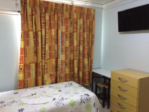 Schlafzimmer mit einem Bett, einem Schreibtisch und einem Vorhang in der Unterkunft Rosa's Hotel in Toledo