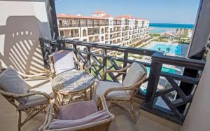 een balkon met stoelen en een tafel en uitzicht op de oceaan bij Premium sea view 2 bedrooms 2 bathrooms apartment located within Gravity Hotel & Aquapark Hurghada in Hurghada