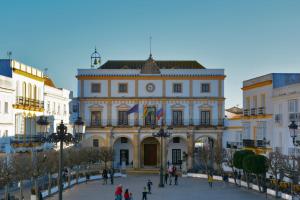 ein großes Gebäude mit einer Uhr oben drauf in der Unterkunft Alojamientos Plaza de España in Medina-Sidonia