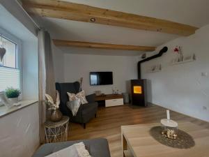 a living room with a couch and a tv at Ferienhaus Göbel´s gute Stube in Wirfus