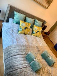 a bed with blue and yellow pillows on it at Renovated Miner’s Cottage - family & dog friendly in Abertillery