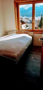 un letto in una camera con una grande finestra di Ferienwohnungen Miklautsch a Faak am See