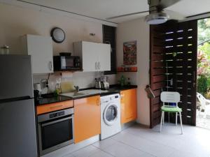 a kitchen with a washing machine and a dishwasher at L'anse et la mer in Cayenne