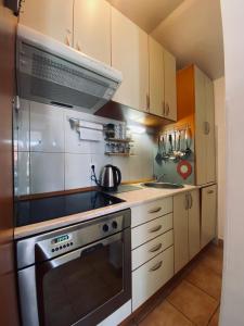 a kitchen with white cabinets and a stove top oven at Beachfront two bedroom apartment Angelina in Đenovići +11 photos