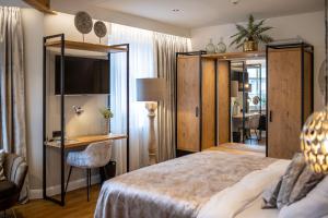 a bedroom with a bed and a desk and a chair at Boutique Hotel Melchers in Vechta