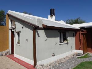 une maison blanche avec un toit et une fenêtre dans l'établissement Flor de las Sierras, à Capilla del Monte