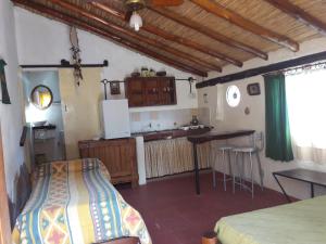 a bedroom with a bed and a kitchen in a house at Flor de las Sierras in Capilla del Monte
