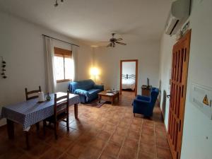ein Wohnzimmer mit einem Tisch und einem blauen Sofa in der Unterkunft Cortijo La Estrella in Vélez Rubio