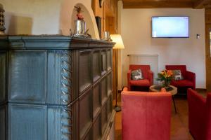ein Wohnzimmer mit 2 roten Stühlen und einem TV in der Unterkunft Hotel Residence Metropol in Seefeld in Tirol