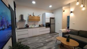eine Küche und ein Wohnzimmer mit einem Sofa und einem Tisch in der Unterkunft Gilboa cliffs- boutique suite in Nurit