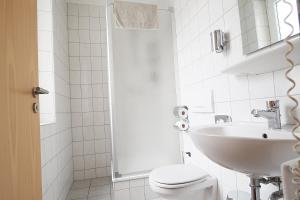 une salle de bain blanche avec toilettes et lavabo dans l'établissement Hotel Europa - Restaurant, à Rüsselsheim 14 autres photos