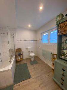 a bathroom with a tub and a toilet and a shower at Ferienhaus Göbel´s gute Stube in Wirfus