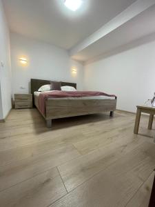 1 dormitorio con 1 cama y suelo de madera en Casa Zorilor, en Şugag