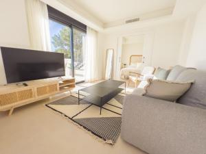 a living room with a couch and a flat screen tv at PENTHOUSE IN GOLDEN MILE in Marbella