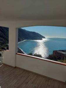 a room with a large window with a view of the ocean at AMARE IL MARE Affittacamere in Corniglia