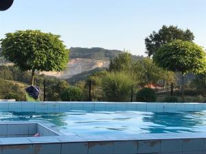 a swimming pool with trees and mountains in the background at Luxeriöse Villa mit Bergblick in Donji Ljenobud