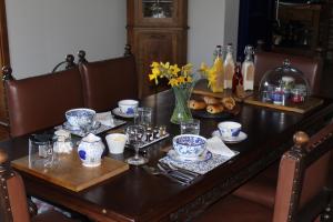 una mesa de comedor con un jarrón de flores. en Hood Lane Farm B&B en Arley