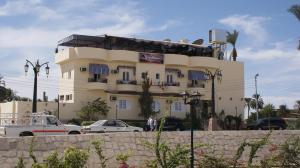 a large building with cars parked in front of it at Nile Valley Hotel in Luxor