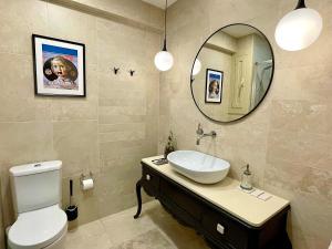 ein Badezimmer mit einem Waschbecken, einem WC und einem Spiegel in der Unterkunft Abbott apartment old town - 1 min from the beach in Sitges