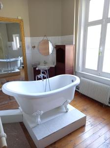 a white bath tub in a bathroom with a mirror at Gîte Chateau baie de somme 10 a 12 personnes in Mons-Boubert