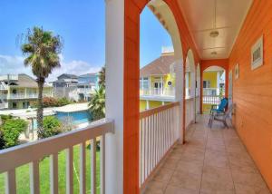 a balcony with a view of the beach and palm trees at 7 Bedroom Home STEPS TO THE BEACH With 4 Patios and Pool! Sleeps 20 in Port Aransas