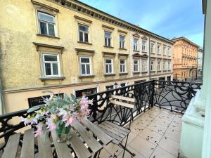 un balcone con panca in legno e vaso di fiori di Pokoje Gościnne Unikat - Self check in a Cracovia