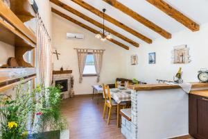 a kitchen and dining room with a table and a fireplace at Villa Bilen in Medulin