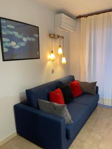 ein Wohnzimmer mit einer blauen Couch mit Kissen in der Unterkunft Sa Calma in Tossa de Mar