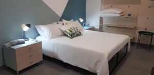 ein Schlafzimmer mit einem großen Bett mit weißen Laken und Kissen in der Unterkunft Fico d'India in Spadafora
