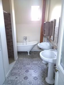 a bathroom with two sinks and a tub and toilet at Gîte Chateau baie de somme 10 a 12 personnes in Mons-Boubert