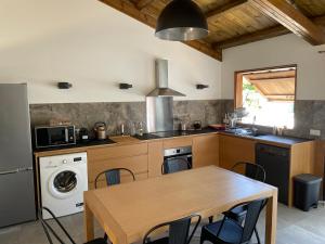 a kitchen with a wooden table and a dining room at Villa Pwintosel 1 in Saint-Leu