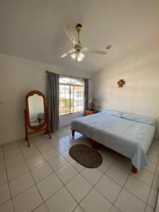 a bedroom with a bed and a ceiling fan at Casa los Titos in Manzanillo +19 photos